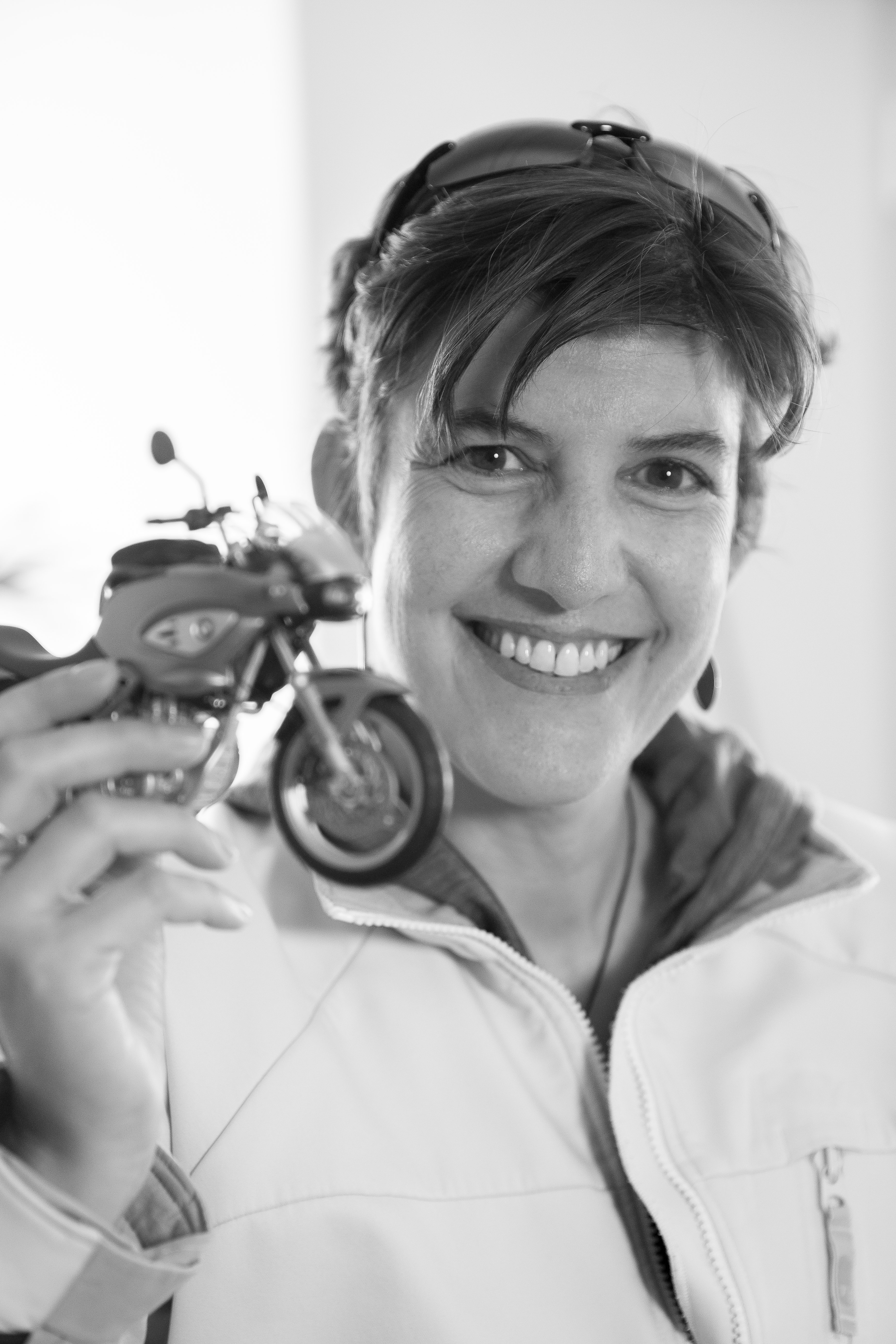 Sandra de Cocatrix, monitrice auto et moto à Sion, tenant une moto miniature