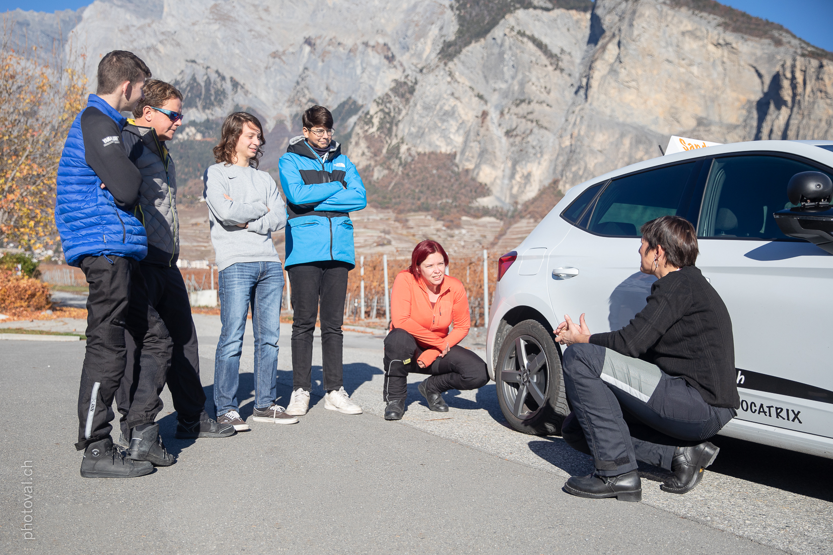 Groupe d'élèves autour de la voiture d'auto-école à Sion, en Valais - Auto / moto école Sandra L