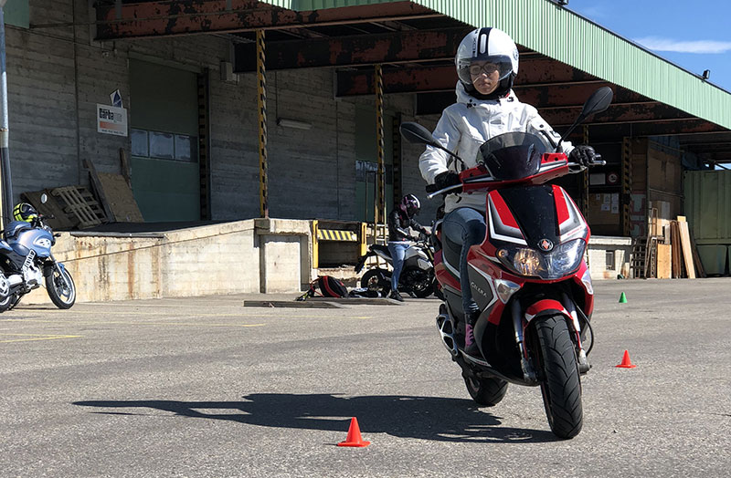 Élève en scooter pendant un exercice de slalom entre cônes à Sion - Auto / moto école Sandra L